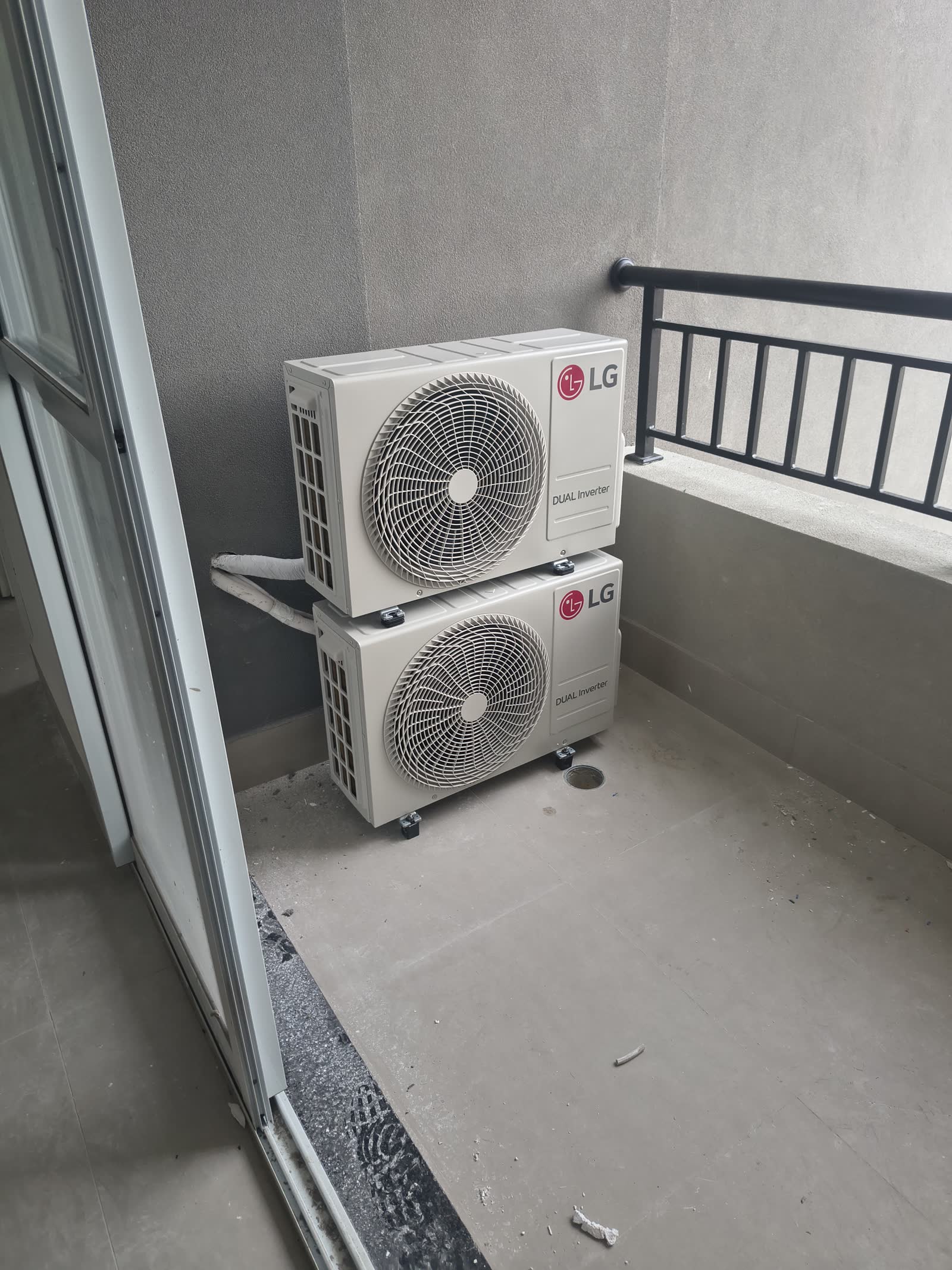 Duas condensadoras LG empilhadas em suporte no canto da sacada de um apartamento