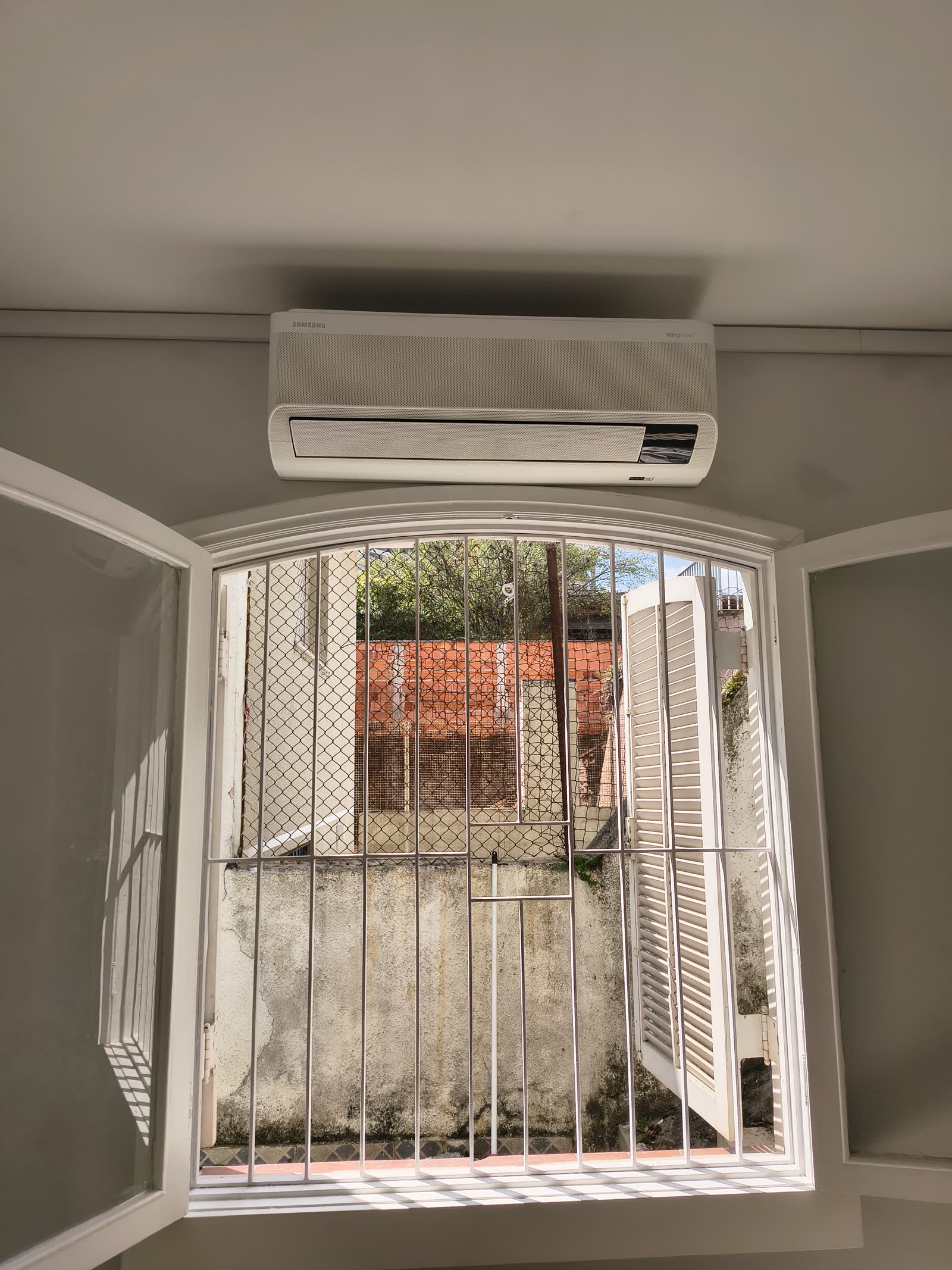 Evaporadora instalada centralizada acima de uma janela em arco